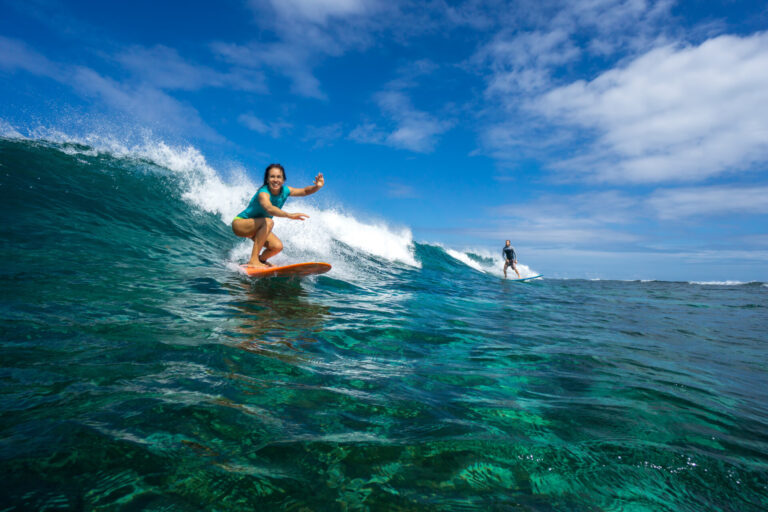 Beautiful girl surfing on big transparent waves